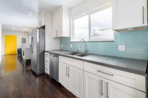 a kitchen with white cabinets and a stainless steel refrigerator at SF City Inn free parking on site in Oakland