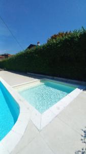 a swimming pool in a yard next to a hedge at Lesa Lake House in Lesa