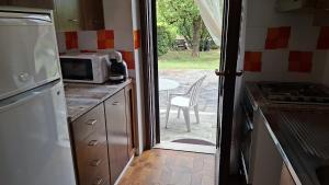 a kitchen with a door open to a patio with a microwave at Lesa Lake House in Lesa