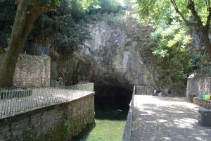 a tunnel in the side of a mountain with people in it at Le Cocon des pierres du Jaur in Saint-Pons-de-Thomières