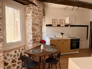 a kitchen with a table and chairs in a room at Le Cocon des pierres du Jaur in Saint-Pons-de-Thomières