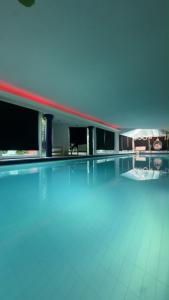 a swimming pool with blue water in a building at Le jardin secret pool and spa in Lasne