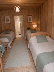 a room with three beds in a wooden room at Stone House marexi in Adishi +108 photos