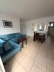 a living room with a blue couch and a table at Słoneczne Ranczo Rowy in Rowy