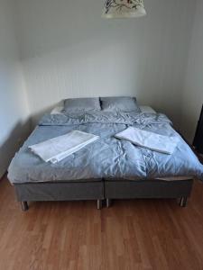 a bed with two white towels on top of it at U Maxa , całe mieszkanie na wyłączność in Sogndal
