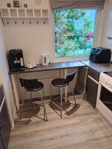 a kitchen with two chairs and a counter and a window at U Maxa , całe mieszkanie na wyłączność in Sogndal +17 photos