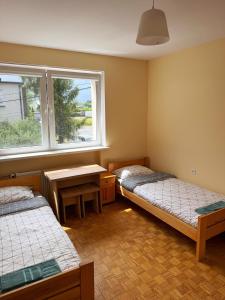 a room with two beds and a table and a window at Górna Residence&Rooms in Grudziądz
