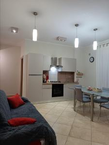 a living room and kitchen with a couch and a table at Casa Letizia in Lercara Friddi