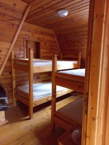 two bunk beds in a cabin with wooden walls at Vikendica Lovinovic Vlasic in Šišava