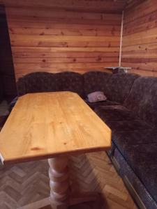 a couch with a wooden table in a room at Vikendica Lovinovic Vlasic in Šišava +5 photos