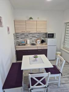 a small kitchen with a table and two chairs at Apartman Lidija in Pag +25 photos