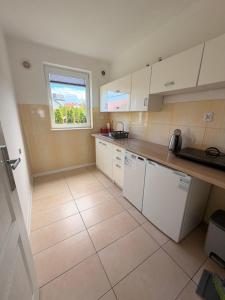 a kitchen with white cabinets and a window at Słoneczne Ranczo Rowy in Rowy