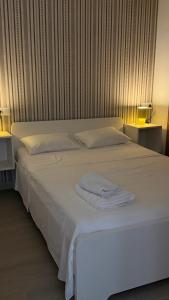 a white bed with two white towels on it at Apartamentos FELIP 2 in Burriana +11 photos