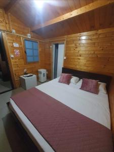 a bedroom with a large bed with a wooden wall at Cazare Balliu in Corbu