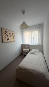 a white bedroom with a bed and a window at Apartamentos FELIP 2 in Burriana