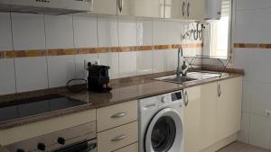 a kitchen with a washing machine and a sink at Apartamentos FELIP 2 in Burriana