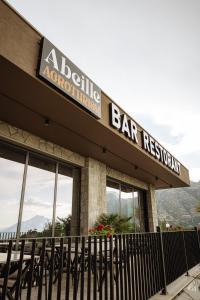 a bar restaurant with a sign on a building at Abeille Rooms in Himare