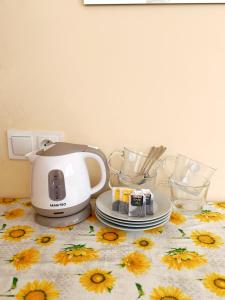 a coffee maker sitting on a table with a sunflower table cloth at Górna Residence&Rooms in Grudziądz