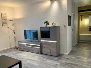 a living room with a flat screen tv on a entertainment center at Appartement Scharf in Bad Harzburg