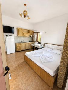 a bedroom with a large bed and a kitchen at Tale Breeze Apartments in Tale