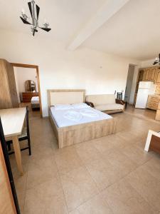 a bedroom with a bed and a couch and a table at Tale Breeze Apartments in Tale