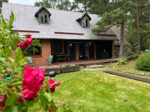 a house with a patio and a yard with flowers at Ūbelītes in Pērkone