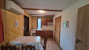 a small room with a table and a kitchen at Amber coast - domek nr 5 in Jantar