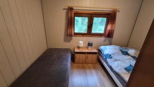 a small bedroom with a bed and a window at Amber coast - domek nr 5 in Jantar