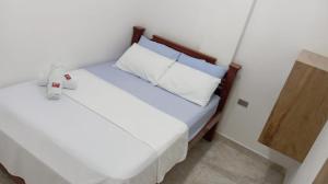 a bedroom with a white bed with a wooden headboard at Hotel Panther Resort in Necoclí