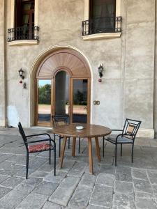 a wooden table and chairs in front of a building at Villa Peschiera in Gazzo