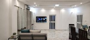 a living room with a couch and a tv on the wall at Appartement moderne avec balcon in Lomé
