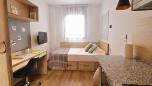 a bedroom with a bed and a desk with a computer at StepHouse Pamplona in Pamplona
