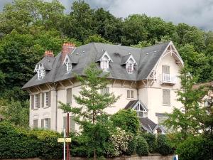 a large white house with a black roof at Villa Hestia B&B de charme dans une villa historique face aux thermes in Contrexéville