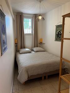 two beds in a small room with a window at La Fontaine du Soleil in Salernes