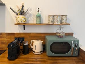 a microwave sitting on top of a wooden floor at La Fontaine du Soleil in Salernes