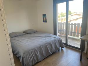 a bedroom with a bed and a large window at Maison de vacances à Bordeaux in Le Haillan +17 photos