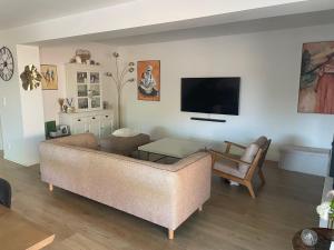 a living room with a couch and a tv at Maison de vacances à Bordeaux in Le Haillan