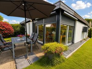 a patio with an umbrella and a table and chairs at Zwischen Schlei & Ostsee in Kappeln