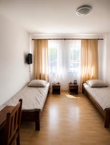 a room with two beds and a window at Pensjonat Rowy Blisko Morza in Rowy