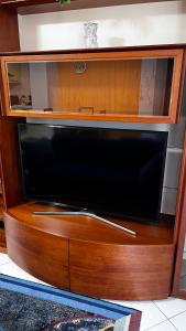 a wooden entertainment center with a flat screen tv at nido delle farfalle in Stazione di Chiusi