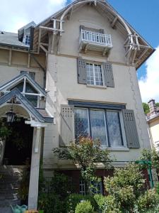 a white house with windows and a porch at Villa Hestia B&B de charme dans une villa historique face aux thermes in Contrexéville +19 photos