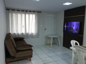 a living room with a chair and a tv at Recanto da Colônia in Ponta Grossa
