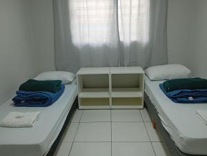 two twin beds in a room with a window at Recanto da Colônia in Ponta Grossa