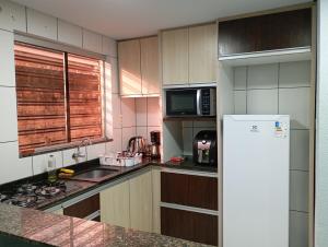 a kitchen with a refrigerator and a counter top at Recanto da Colônia in Ponta Grossa