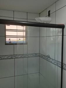 a bathroom with a glass shower with a window at Recanto da Colônia in Ponta Grossa +5 photos