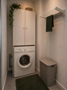 a laundry room with a washing machine and a cabinet at MeBa Living Business Suite Mönchengladbach in Mönchengladbach