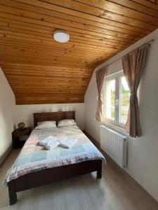 a bedroom with a bed with a wooden ceiling at House Bozovic in Žabljak