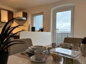 a dining room table with plates and cups on it at Helles Maisonette Apartment, Balkon, all-in 5G in Gera