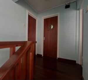 a hallway with a wooden door with a clock on it at coubaril Manor in Castries +5 photos