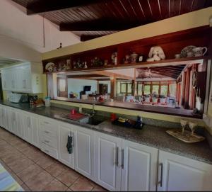 a kitchen with white cabinets and a large mirror at coubaril Manor in Castries